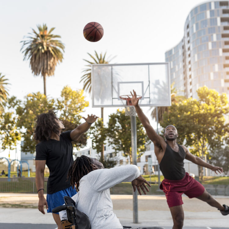 hombre-discapacitado-en-silla-de-ruedas-jugando-baloncesto-con-personas